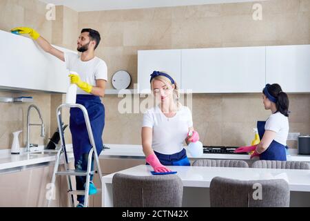Servizio di pulizia squadra al lavoro in cucina in casa privata Foto Stock