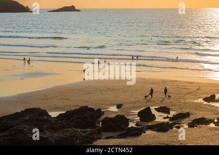 Cornwall England Beach, vista al tramonto delle persone che camminano sulla Fistral Beach vicino a Newquay in Cornovaglia, Inghilterra sud-occidentale, Regno Unito Foto Stock