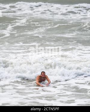 Brighton UK 24 settembre 2020 - UN nuotatore breccia il mare in una giornata ventosa a Brighton con previsioni meteo più indefinite per la Gran Bretagna nei prossimi giorni: Credit Simon Dack / Alamy Live News Foto Stock