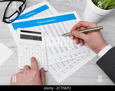 Uomo che esamina i documenti finanziari Foto Stock