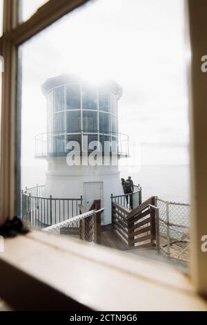 Vista pittoresca del faro di scoscia situato sulla riva sullo sfondo di mare calmo Foto Stock