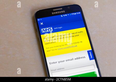 L'app NHS Track and Trace sullo schermo di Un telefono cellulare Android con un messaggio di volume elevato di traffico può ritardare l'applicazione Foto Stock