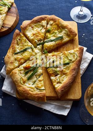 Pizza vegetariana con fiori di zucchine, cipolla, zucchine e formaggio Foto Stock