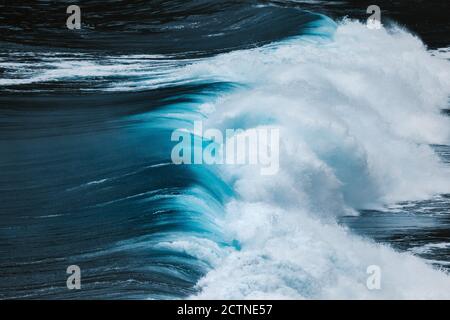 Dall'alto si può ammirare il potente blu che infrangono le onde dell'oceano schiuma bianca Foto Stock