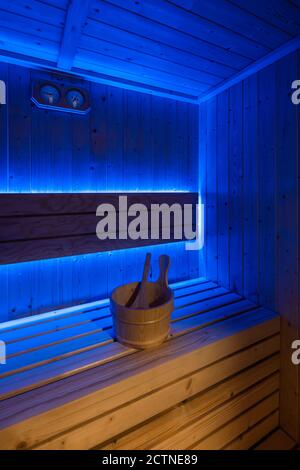 Particolare della sauna tradizionale con interni in legno e panca illuminata da lampada ultravioletta Foto Stock