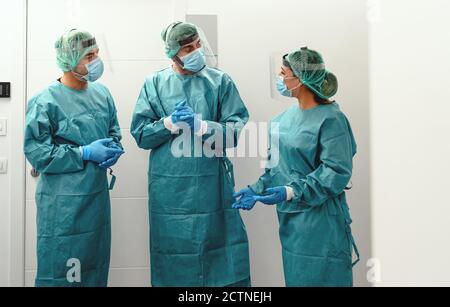 I medici che indossano apparecchiature dpi si trovano a fronteggiare la maschera chirurgica e la visiera contro l'epidemia di corona virus Foto Stock