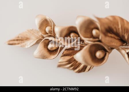 Alto angolo di tornante fatto a mano con fiori dorati e foglie posto sul tavolo in officina Foto Stock