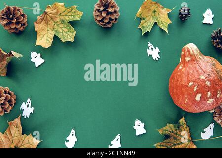 Composizione autunnale. Telaio fatto di zucche, foglie secche e sfondo decorativo fantasmi. Modello autunno, autunno, Halloween, raccolta di ringraziamento Foto Stock