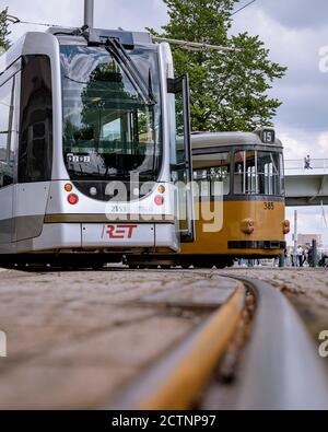 Un vecchio e un nuovo tram l'uno accanto all'altro nel centro della città di Rotterdam. Primo piano mostra una sezione di traccia in una curva. Foto Stock