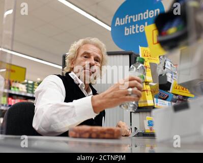 Rastatt, Germania. 24 Settembre 2020. L'intrattenitore Thomas Gottschalk siede come cassiere volontario presso la cassa di una filiale di Netto Marken-Discount e calcola gli acquisti dei clienti. Egli è scivolato nel ruolo di cassiere per il movimento di donazione 'Deutschland runden auf'. Le donazioni di depositi e gli importi di piccolo centesimo sono destinati a sostenere i bambini socialmente svantaggiati. Credit: Uli Deck/dpa/Alamy Live News Foto Stock