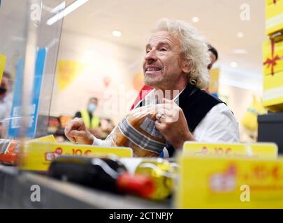 Rastatt, Germania. 24 Settembre 2020. L'intrattenitore Thomas Gottschalk siede come cassiere volontario presso la cassa di una filiale di Netto Marken-Discount e calcola gli acquisti dei clienti. Egli è scivolato nel ruolo di cassiere per il movimento di donazione 'Deutschland runden auf'. Le donazioni di depositi e gli importi di piccolo centesimo sono destinati a sostenere i bambini socialmente svantaggiati. Credit: Uli Deck/dpa/Alamy Live News Foto Stock