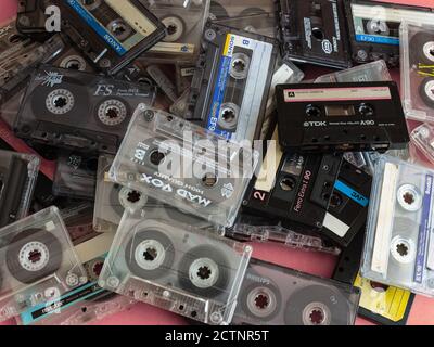 Vista dall'alto flat Lay Stack vintage poche cassette compatte set di vecchi nastri audio su sfondo rosa. Foto Stock