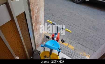 Foto ad alto angolo di una bicicletta colorata per bambini in un porta prima della strada Foto Stock