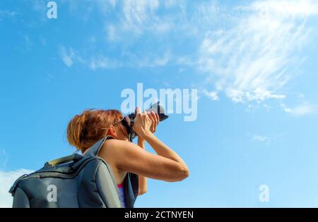 Vista posteriore di una donna che scatta una foto al sole giorno Foto Stock