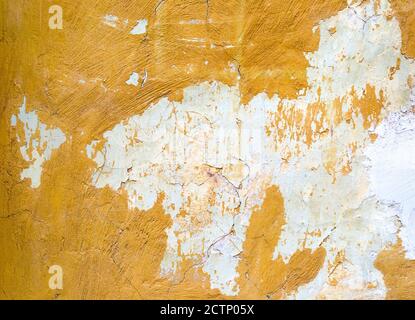 Sfondo o struttura della parete di cemento giallo verniciato fessurato Foto Stock