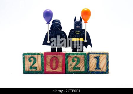 il batman lego e il vader darth tengono una mongolfiera che celebra il nuovo anno 2021, utilizzando un blocco di legno. Foto Stock