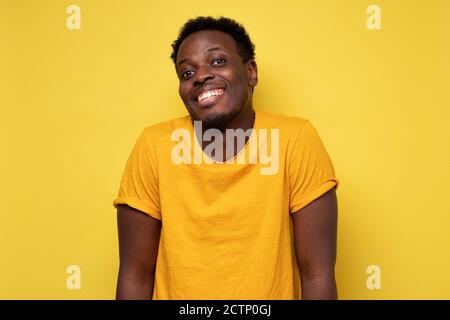 Sorridente giovane afroamericano su sfondo giallo Foto Stock