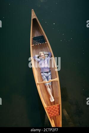 Uomo singolo che si rilassa in canoa Foto Stock