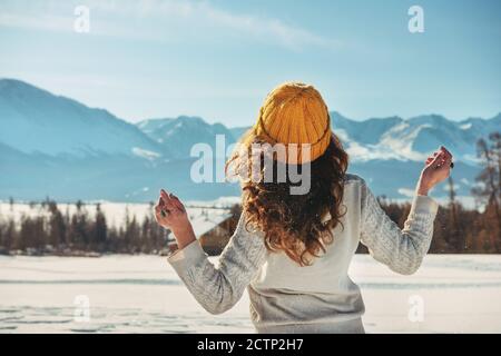 Attraente giovane ragazza cammina in montagne innevate Foto Stock