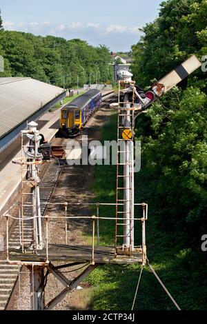 Treno Northern Rail classe 156 che passa il semaforo di staffetta alla stazione ferroviaria di Poulton-le-Fylde Foto Stock