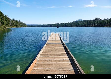 Un lungo molo che si affaccia sul lago Suttle, un lago naturale di montagna nelle Cascade Mountains, vicino a Sisters, Oregon. Foto Stock
