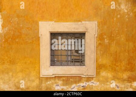 ROMA, ITALIA - 2014 AGOSTO 17. Parete gialla con finestra con barre. Foto Stock