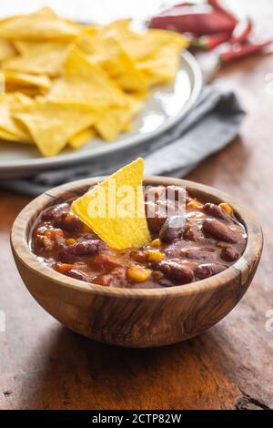 Chili con carne e tortilla chips. Cibo messicano con fagioli in ciotola di legno. Foto Stock