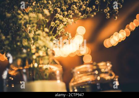 Fiori bianchi di nozze in un vaso seduto su un tavolo Foto Stock