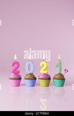 Torte di tazza con 2021 candele su sfondo colorato isolato. Tema Felice anno nuovo. Illustrazione 3D Foto Stock