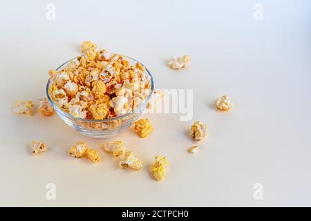 Una ciotola trasparente di popcorn su una superficie leggera. Spazio di copia. Foto Stock