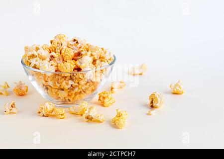 Una ciotola trasparente di popcorn su una superficie leggera. Spazio di copia. Foto Stock