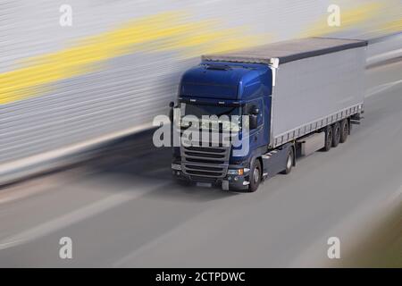 Un carrello a movimento rapido su un'autostrada circondata da barriere acustiche. Foto Stock