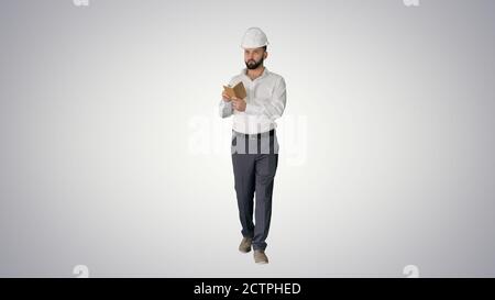 Uomo maturo sicuro in formalwear e hardhat scrivere nota Foto Stock