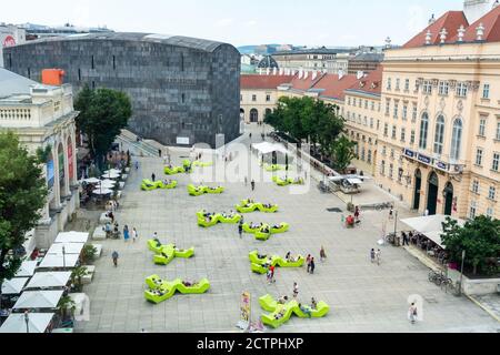 Vienna, Austria – 3 giugno 2017. Vista su Museumsplatz nel Museumsquartier di Vienna, verso MUMOK e Hofstallungen complesso, con la gente. Foto Stock