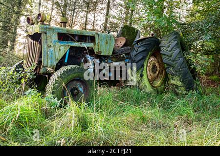Un vecchio trattore arrugginito in disuso nel bosco Foto Stock