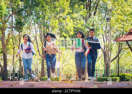 Studenti in estate Bambini con zaini in piedi nel parco vicino alla scuola. Alunni con libri e zaini all'aperto Foto Stock