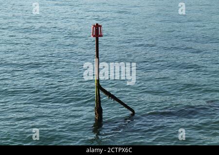 Il marcatore alla fine di un Groyne di legno a lato del mare. Foto Stock