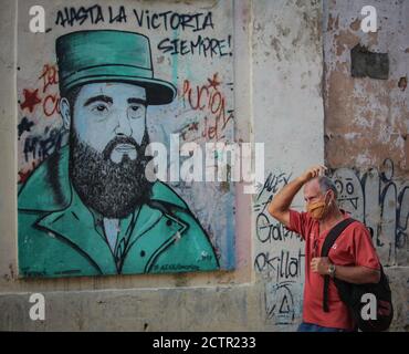 Havanna, Cuba. 24 Settembre 2020. Un uomo con una guardia bocca e naso cammina di fronte a un murale dell'ex presidente cubano Fidel Castro. A Cuba, 5310 persone hanno contratto Covid-19. Credit: Guillermo Nova/dpa/Alamy Live News Foto Stock