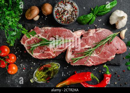 Cibo sfondo. Filetto di maiale fresco con spezie, erbe e verdure. Disposizione piatta, vista dall'alto Foto Stock