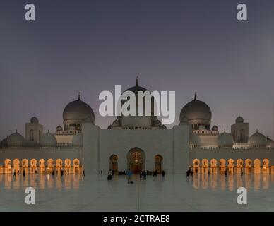 Le cupole della Grande Moschea Sheikh Zayed mentre il sole tramonta su Abu Dhabi, Emirati Arabi Uniti Foto Stock