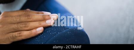 Uomo africano spazzolando Dandruff da vestito sporco Foto Stock