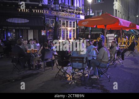 I bevitori di tarda notte a Soho, Londra, come da oggi i pub e i ristoranti saranno soggetti a un coprifuoco alle 22:00 per combattere l'aumento dei casi di coronavirus in Inghilterra. Foto Stock