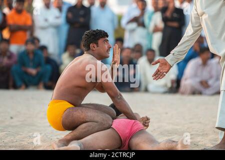 Arbitro domanda manovra di un lottatore Kushti contro un altro a Dubai, Emirati Arabi Uniti (Emirati Arabi Uniti) Foto Stock