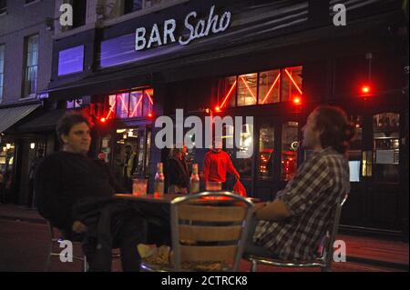 I bevitori di tarda notte a Soho, Londra, come da oggi i pub e i ristoranti saranno soggetti a un coprifuoco alle 22:00 per combattere l'aumento dei casi di coronavirus in Inghilterra. Foto Stock