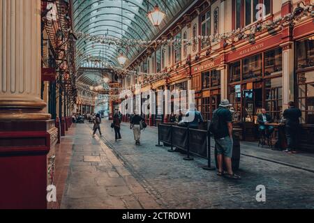 Londra, UK - 24 agosto 2020: Le persone socialmente distanziate ai tavoli da pub New Moon all'interno della galleria Leadenhall Market. Leadenhall è un mercato popolare i Foto Stock
