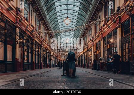 Londra, UK - 24 agosto 2020: Vista posteriore di un uomo che si trova da solo a un tavolo da pub New Moon nella galleria di Leadenhall Market, mercato popolare a Londra Foto Stock