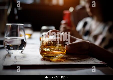 Bicchiere con alcol in mano. Foto Stock