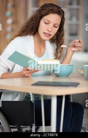 felice giovane donna legge libro e bevande caffè Foto Stock