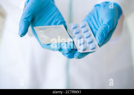 Primo piano di medico femminile che tiene la pillola per la salute degli uomini Foto Stock