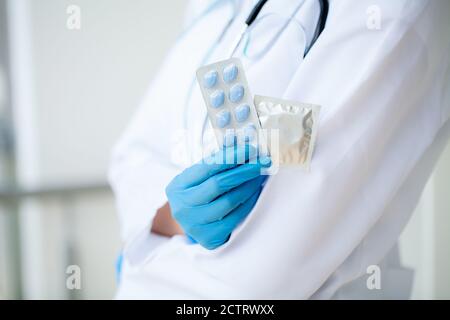 Primo piano di medico femminile che tiene la pillola per la salute degli uomini Foto Stock